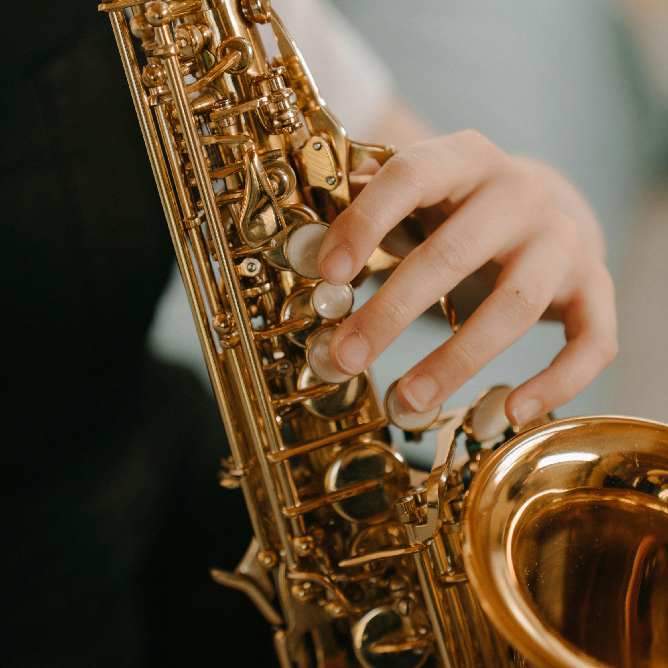 Picture of a saxophone in the hands of a musician.