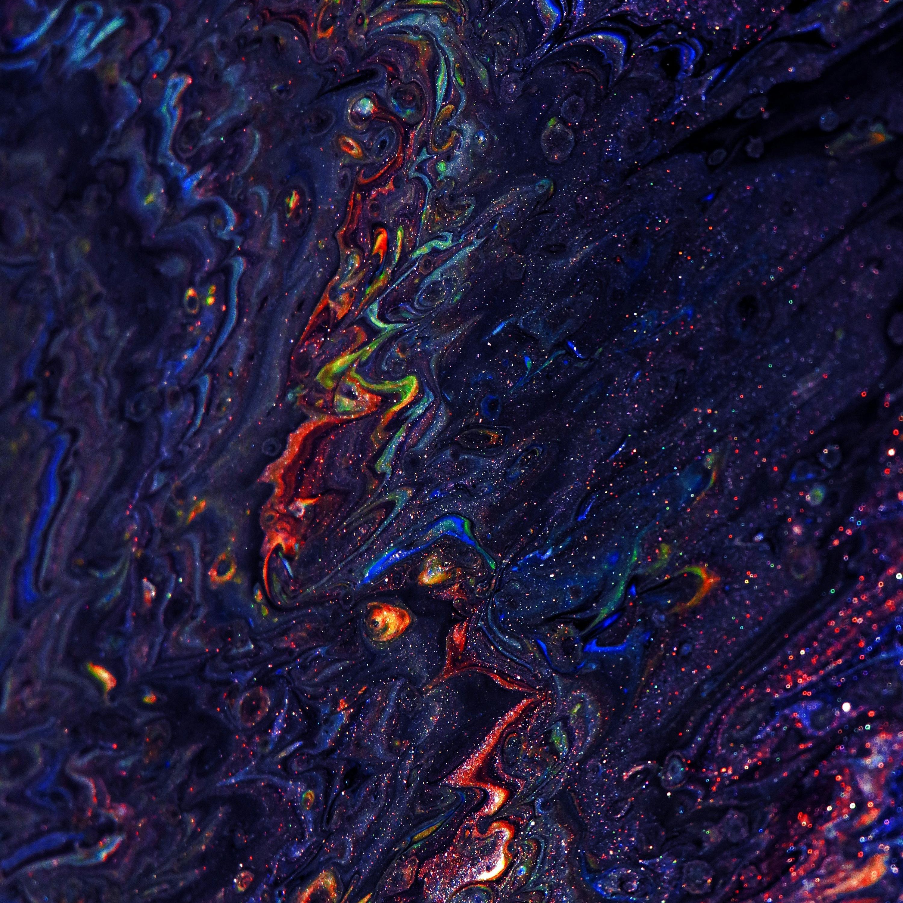 Colourful artwork with dark purple and gliters of red, green and more.